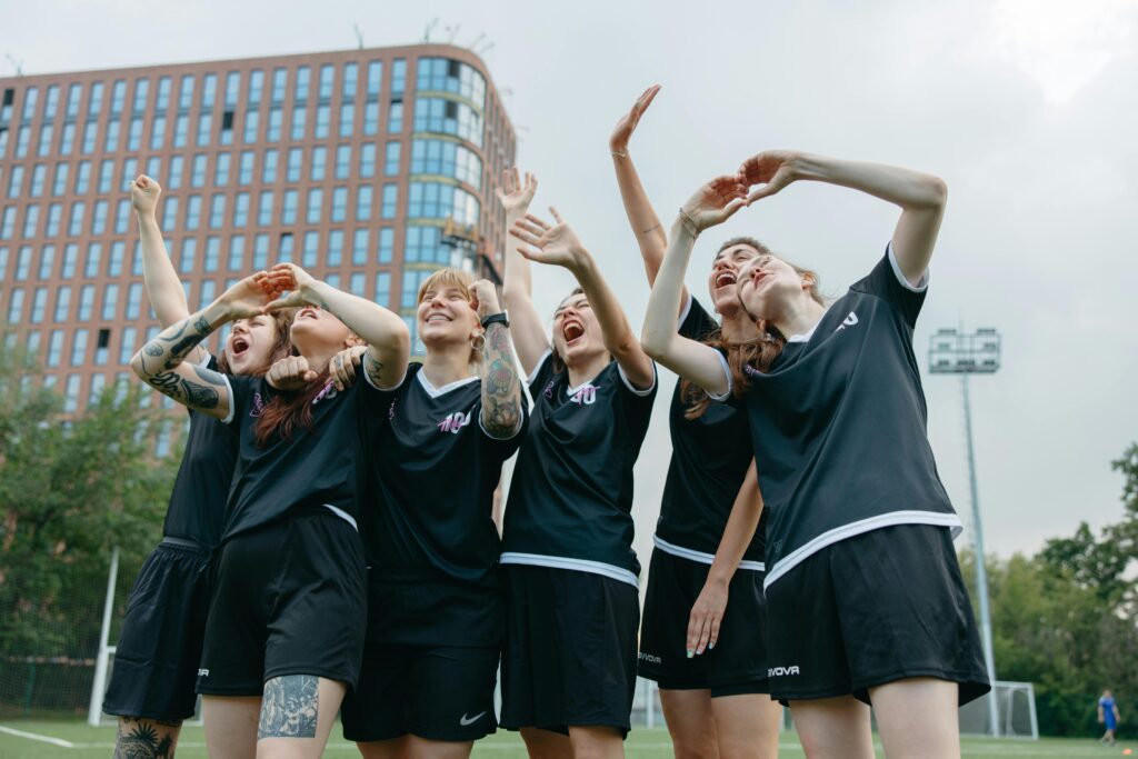 A cheering team of women on a soccer field