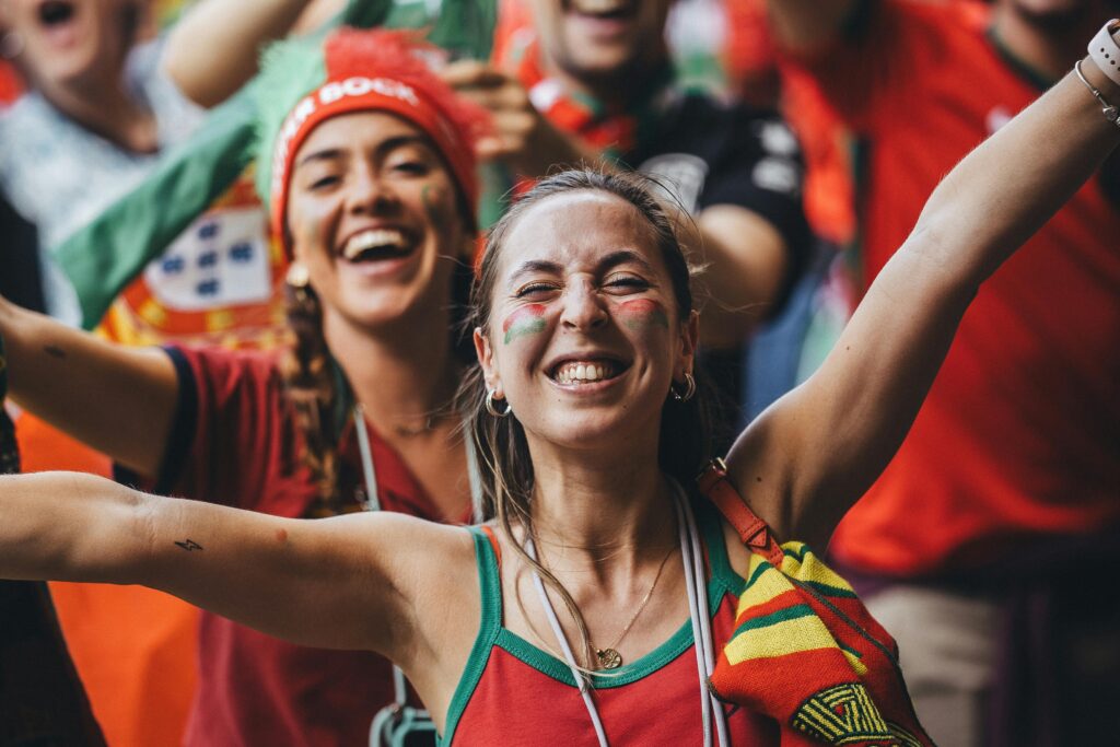 Women cheering at a sports match in their team colors